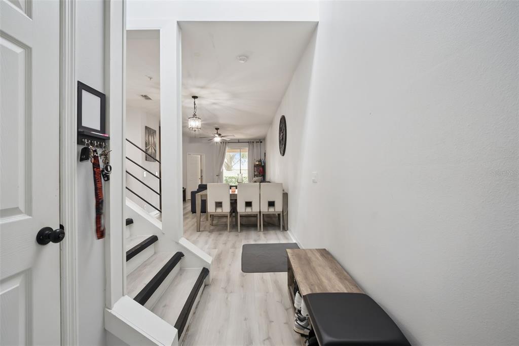 A view from a hallway looking toward a dining area with light wood-look flooring — 1320 GLENLEIGH DRIVE, OCOEE, FL