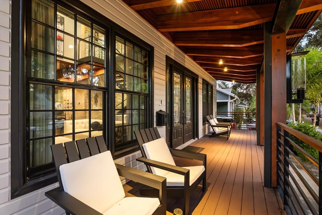 A two-story house with a metal roof and a front porch sits behind a wooden fence — 119 N HYER AVENUE, ORLANDO, FL