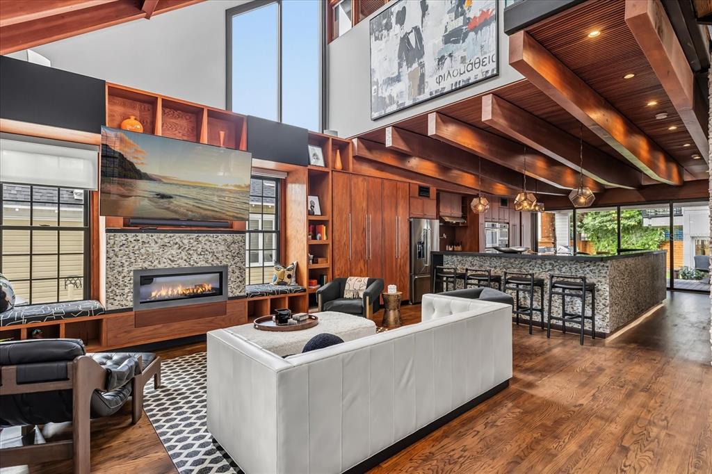 A covered wooden porch features modern black chairs, a metal railing, and exposed wood beams — 119 N HYER AVENUE, ORLANDO, FL