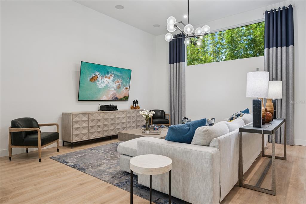 A dining room features a light wood table, dark chairs, and floor-to-ceiling curtains — 512 W SWOOPE AVENUE, WINTER PARK, FL