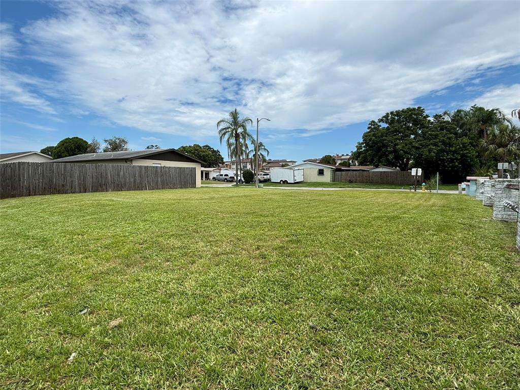 A large, flat, grassy vacant lot is enclosed by a wooden fence — 4368 SUNRAY DRIVE, HOLIDAY, FL