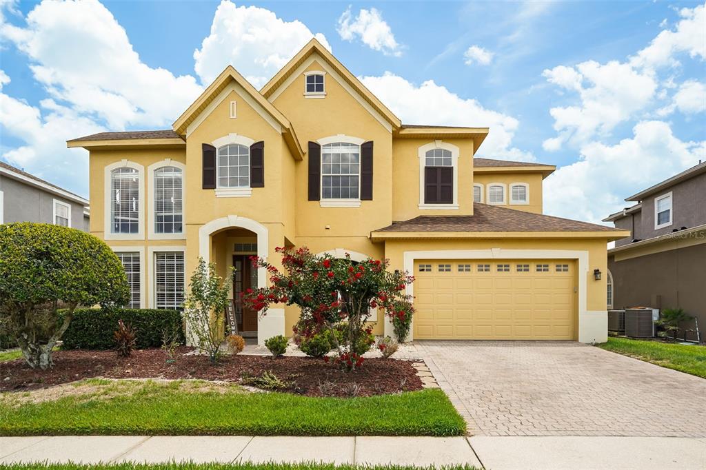An entryway with a staircase, a red accent wall, and a patterned area rug — 1699 SWALLOWTAIL LANE, SANFORD, FL