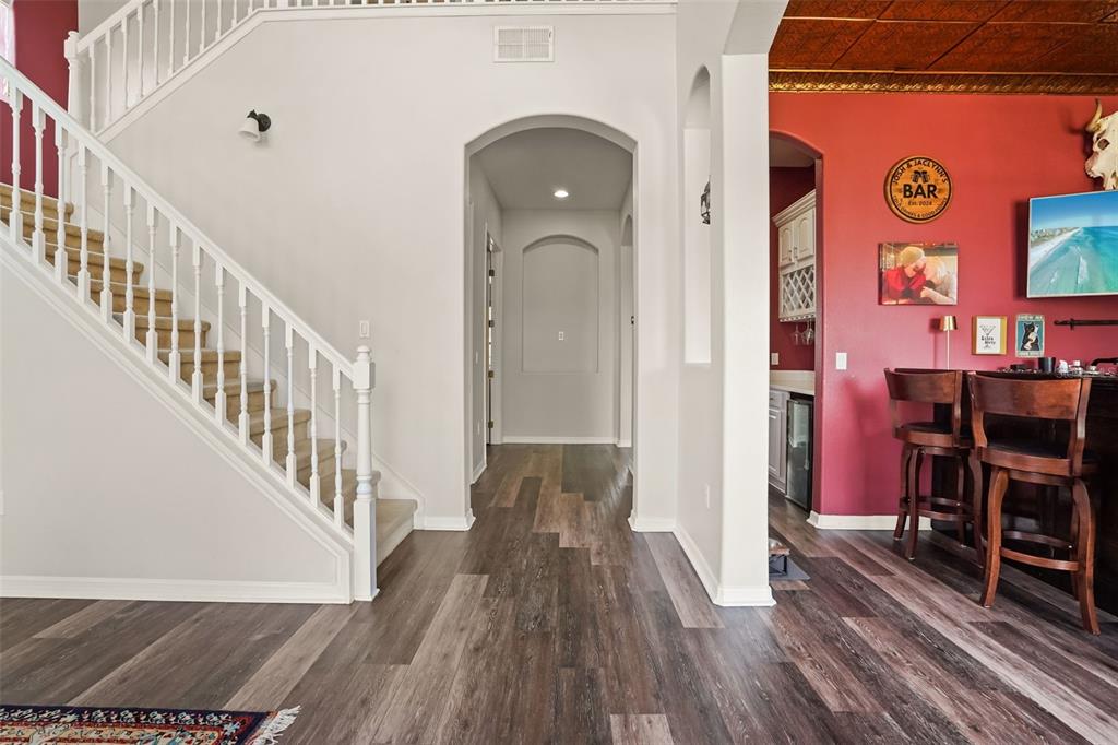 A living room features a red accent wall, a blue sofa, and a patterned rug — 1699 SWALLOWTAIL LANE, SANFORD, FL