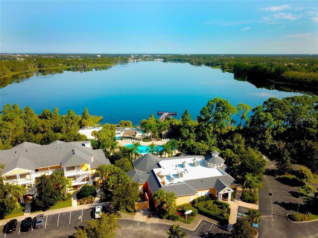 An aerial view shows a large lake, a swimming pool, and two multi-story buildings — 614 RUM RUN, DAVENPORT, FL