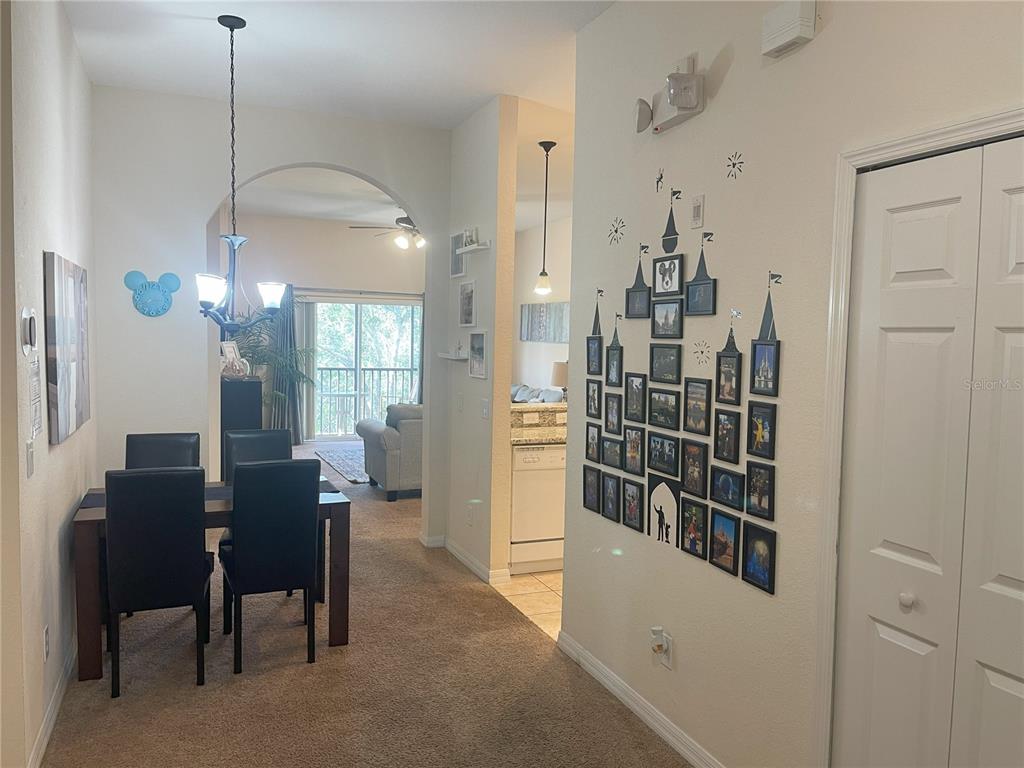 A dining area with a gallery wall leads to a kitchen and a living room — 614 RUM RUN, DAVENPORT, FL