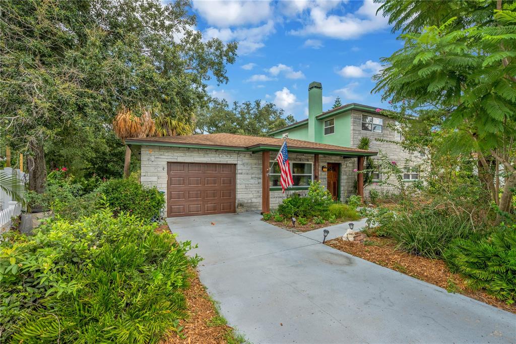 A two-story house with a stone facade, green trim, and a single-car garage — 1708 WOODBINE DRIVE, BRANDON, FL
