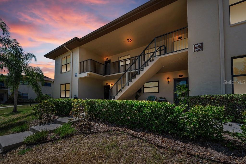 A wooden dock extends into a waterway with a boat, a kayak, and pilings — 1673 SEASCAPE CIRCLE UNIT 102, TARPON SPRINGS, FL
