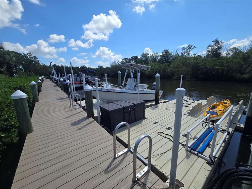 A small bird perches on a wooden piling in a calm, mangrove-lined waterway — 1673 SEASCAPE CIRCLE UNIT 102, TARPON SPRINGS, FL
