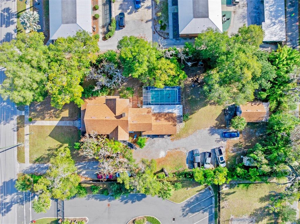 An aerial view shows a house with a brown roof, a pool, and parking — 228 W HOWRY AVENUE, DELAND, FL