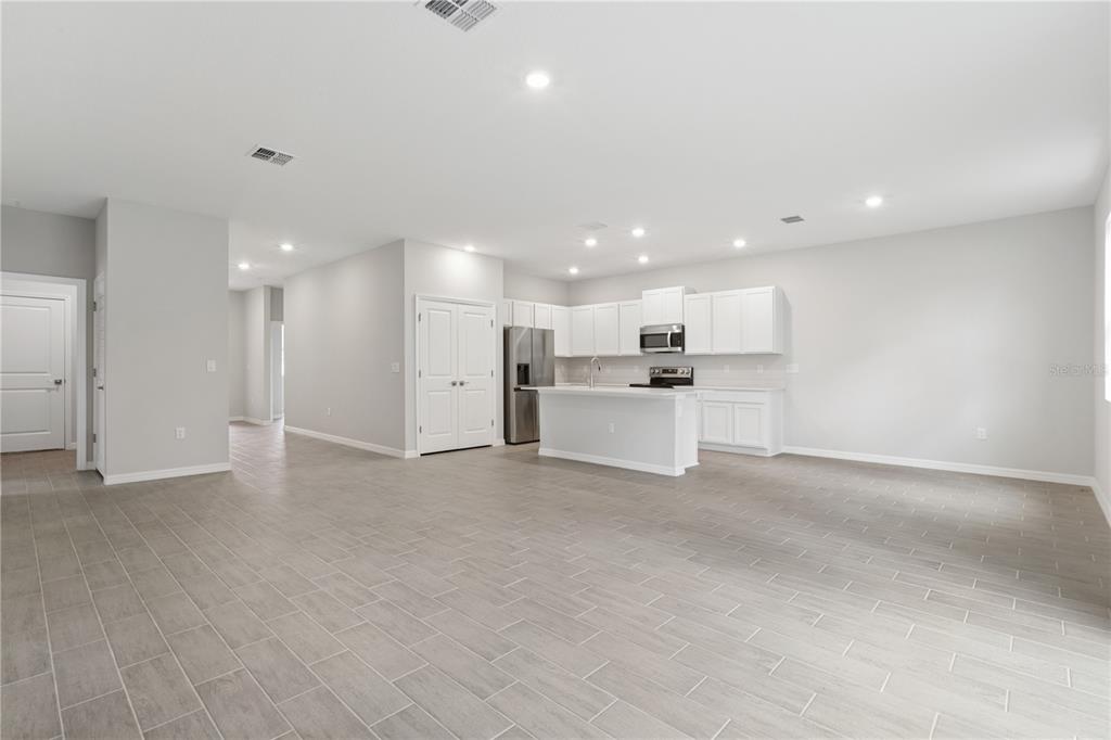 A kitchen with white cabinets, a center island, and gray tile flooring in an open space — 17094 SW 20TH CT ROAD, OCALA, FL