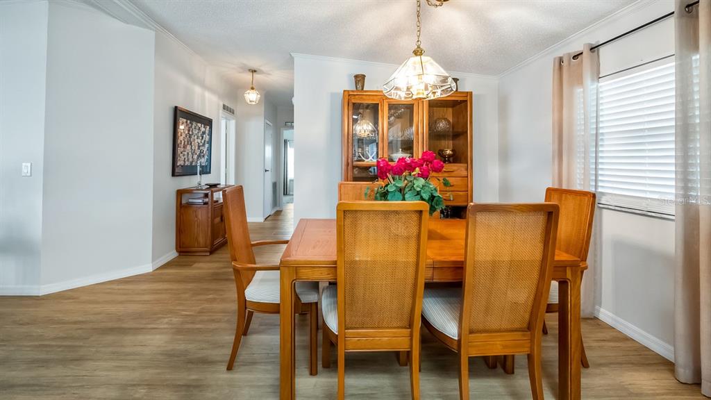 A dining room features a wooden table with four chairs, a hutch, and light flooring — 3109 MANATEE ROAD, TAVARES, FL