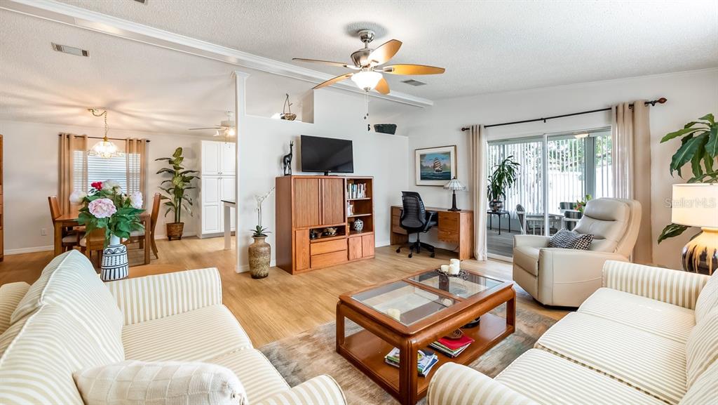A living room features light wood flooring, a ceiling fan, and a glass-topped coffee table — 3109 MANATEE ROAD, TAVARES, FL