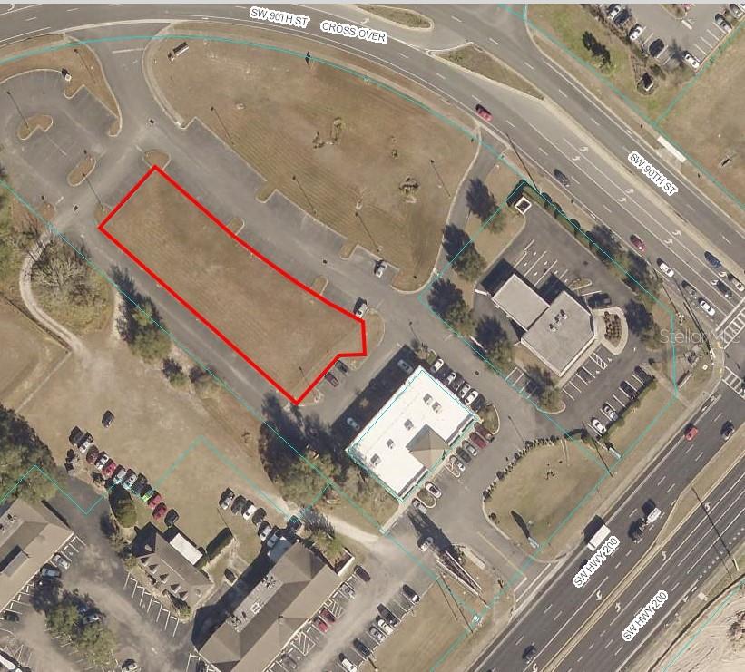 An aerial view shows a vacant rectangular lot outlined in red within a commercial plaza — TBD SW STATE RD 200, OCALA, FL