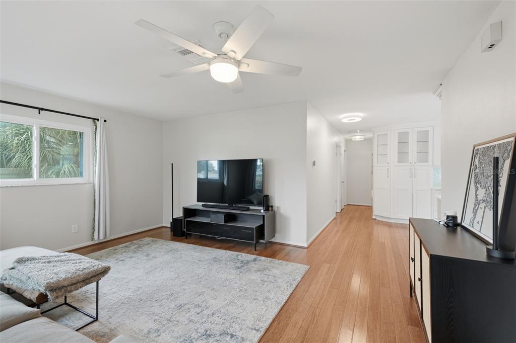 A living room features a gray sectional sofa, a large area rug, and hardwood floors — 205 SE MONROE CIRCLE N, ST PETERSBURG, FL