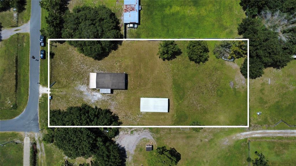An aerial view shows a rectangular lot containing a house, a detached structure, and trees — 4641 A STREET, ST CLOUD, FL
