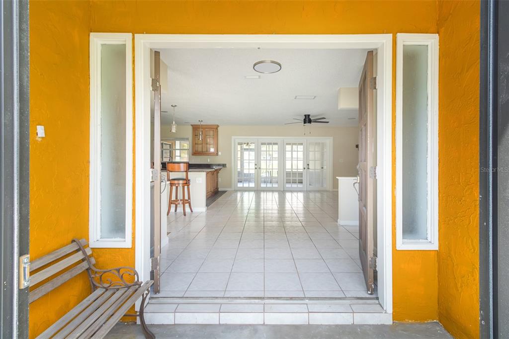A kitchen features wood cabinets, dark granite countertops, stainless steel appliances, and white tile flooring — 3215 LAKE SAXON DRIVE, LAND O LAKES, FL