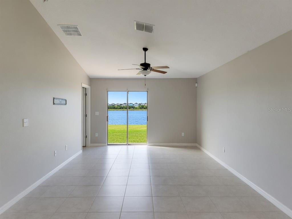 A bedroom with gray walls, wood-look flooring, a ceiling fan, and white closet doors — 838 OLIVE CONCH STREET, RUSKIN, FL