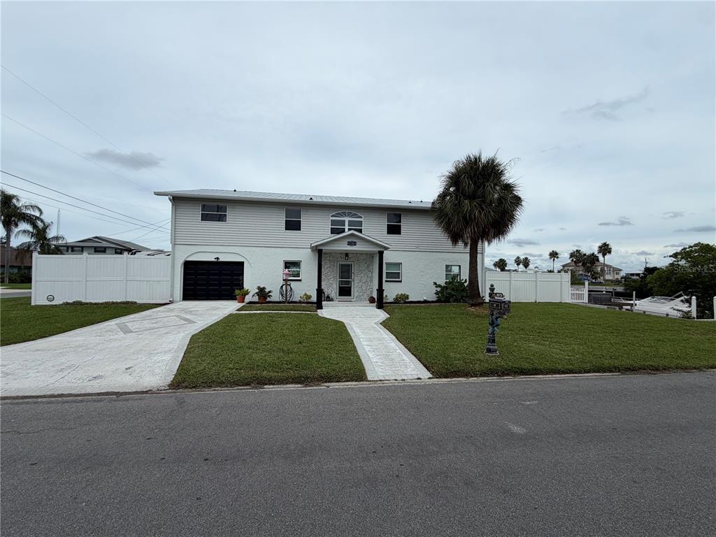A two-story house with a metal roof, white siding, and a single-car garage — 3173 GULFVIEW DRIVE, HERNANDO BEACH, FL