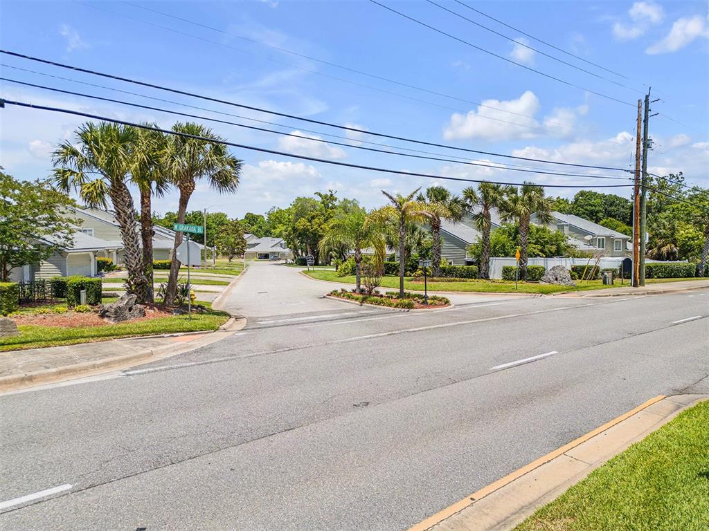 A street view showing a residential entrance with palm trees and multi-family housing units — 24 MISNERS TRAIL, ORMOND BEACH, FL