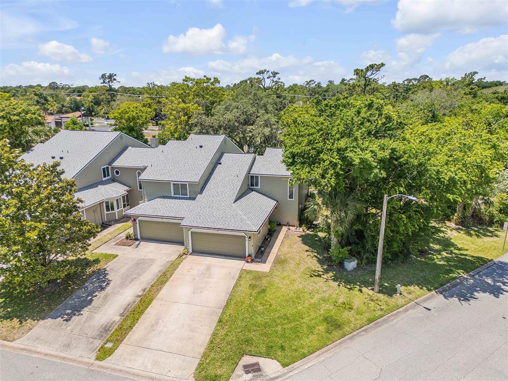 An aerial view of a two-story duplex with attached garages and a grassy front yard — 24 MISNERS TRAIL, ORMOND BEACH, FL