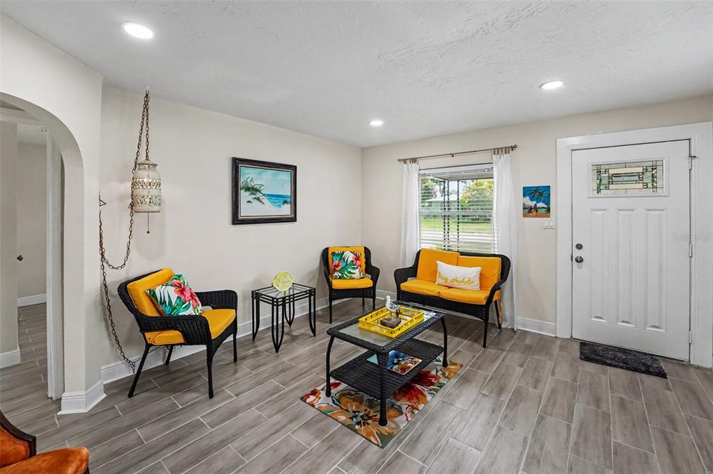 A kitchen with white cabinets, stainless steel appliances, quartz countertops, and a small dining area — 4611 17TH AVENUE N, ST PETERSBURG, FL