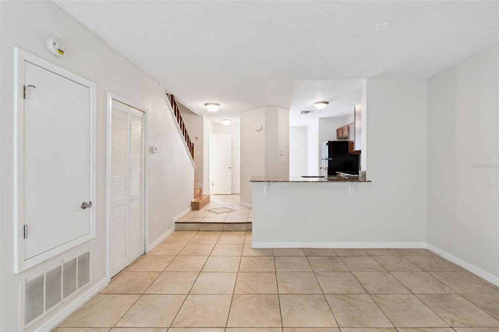 A tiled dining area leads to a kitchen with a breakfast bar and a staircase — 679 CLEMSON DRIVE, ALTAMONTE SPRINGS, FL