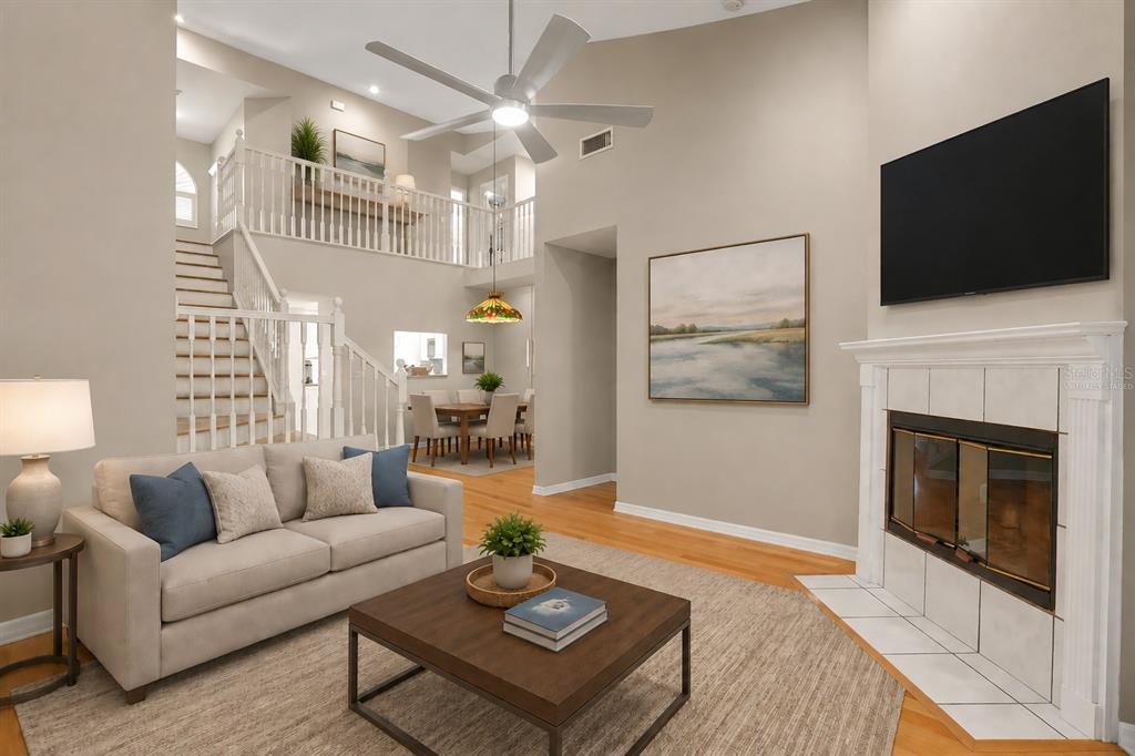 A living room with a fireplace, a staircase, and a dining area in the background — 1937 NORTHFORK CIRCLE, CLEARWATER, FL