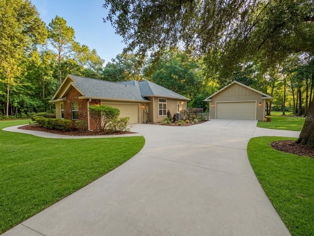 A single-story house with a brick and siding exterior, a two-car garage, and a detached garage — 20273 NW 251ST TERRACE, HIGH SPRINGS, FL