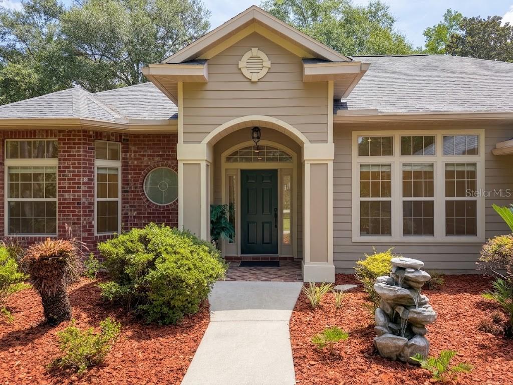 A front view of a house with a brick and tan siding exterior and entryway — 20273 NW 251ST TERRACE, HIGH SPRINGS, FL