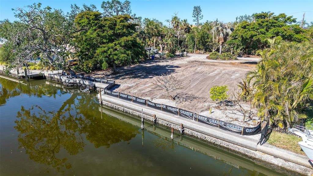 An aerial view of a vacant, cleared waterfront lot with a concrete seawall and silt fencing — 660 LONGVIEW DRIVE, LONGBOAT KEY, FL