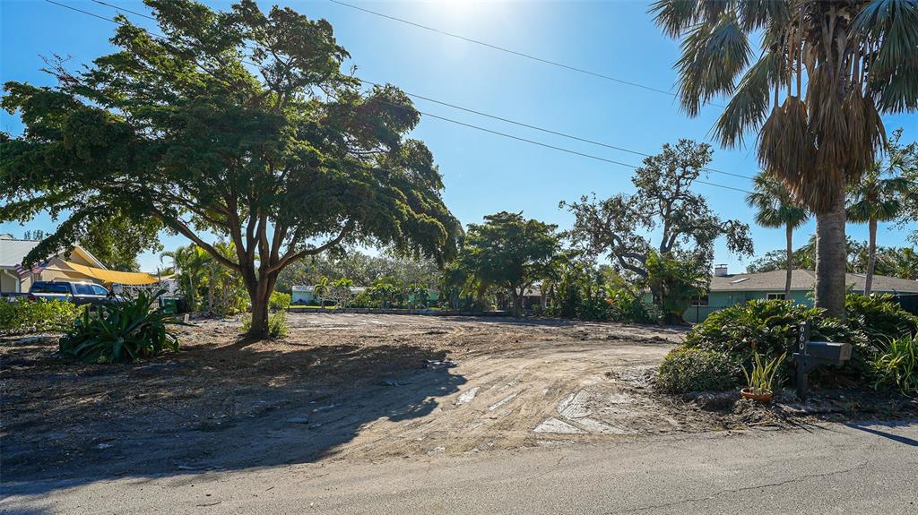 A vacant, cleared residential lot features mature trees and a mailbox along a paved road — 660 LONGVIEW DRIVE, LONGBOAT KEY, FL
