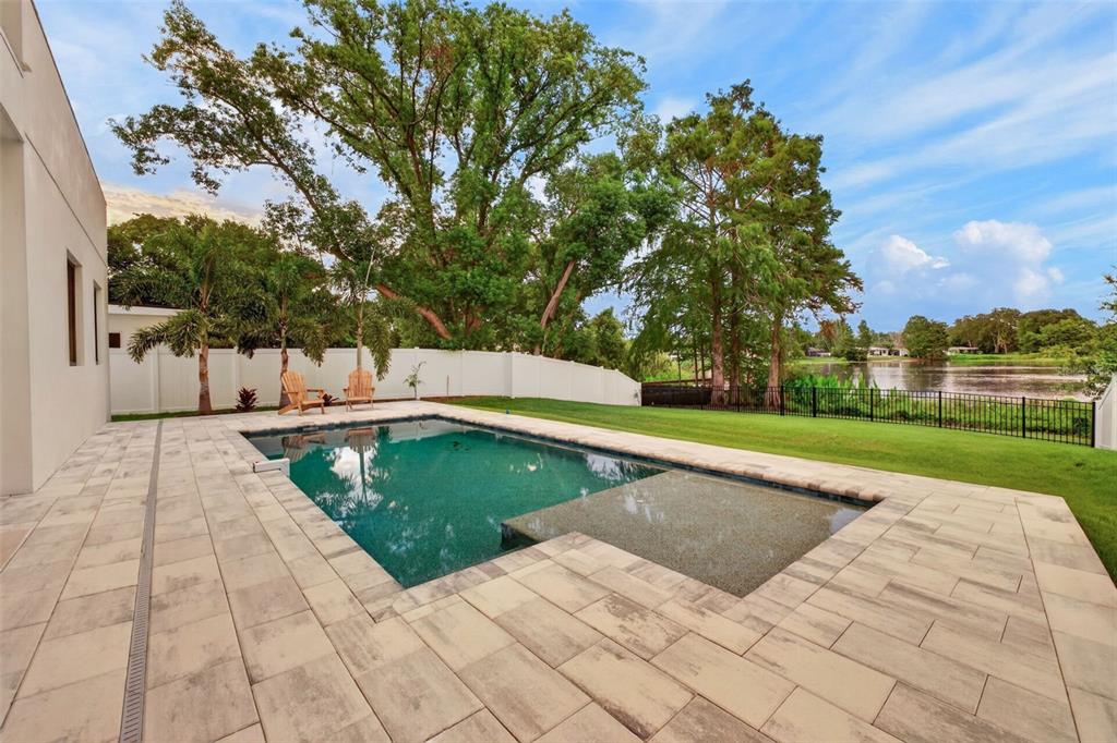 A modern two-story house features a white stucco exterior, wood siding, and a two-car garage — 1205 FALCON DRIVE, ORLANDO, FL