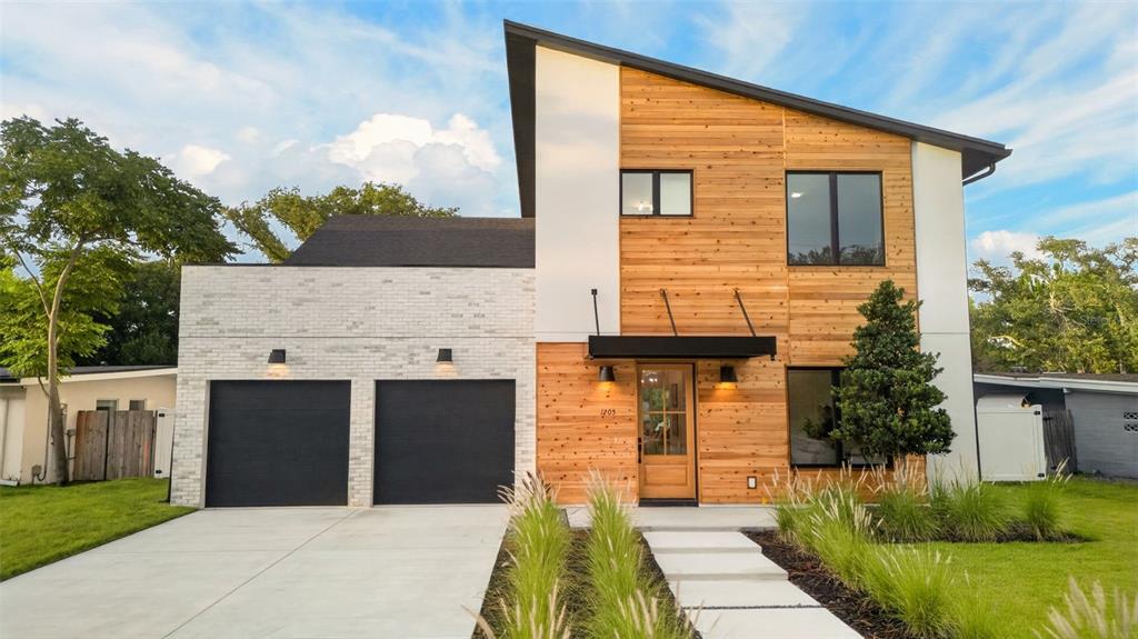 A modern house exterior features horizontal wood siding, a black metal awning, and a glass door — 1205 FALCON DRIVE, ORLANDO, FL