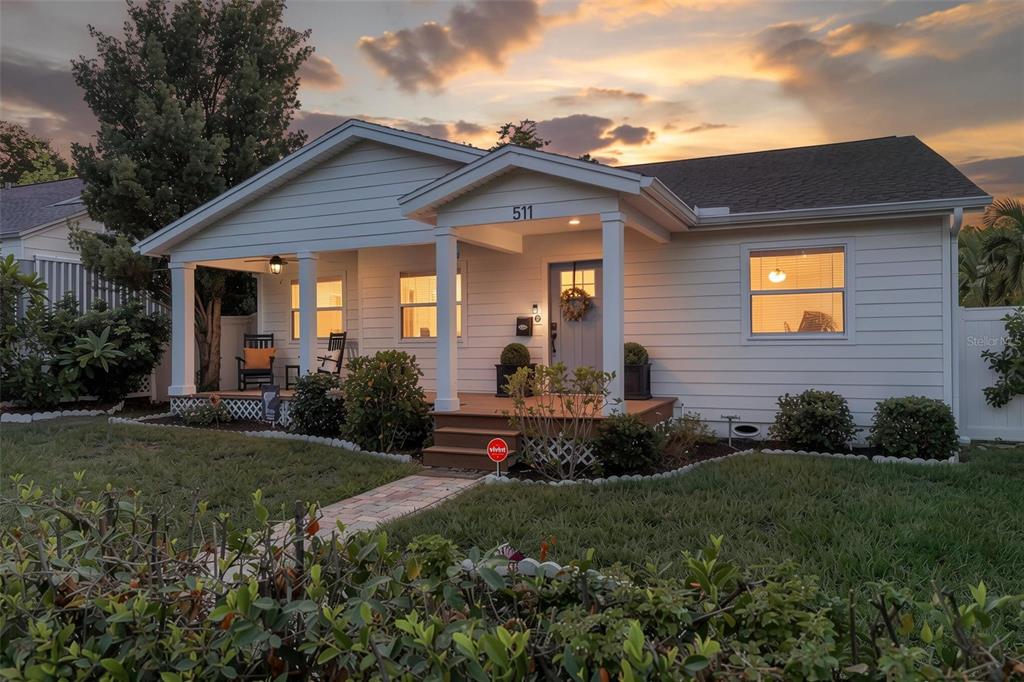A white, single-story house with a front porch and a brick walkway at sunset — 511 25TH AVENUE N, ST PETERSBURG, FL