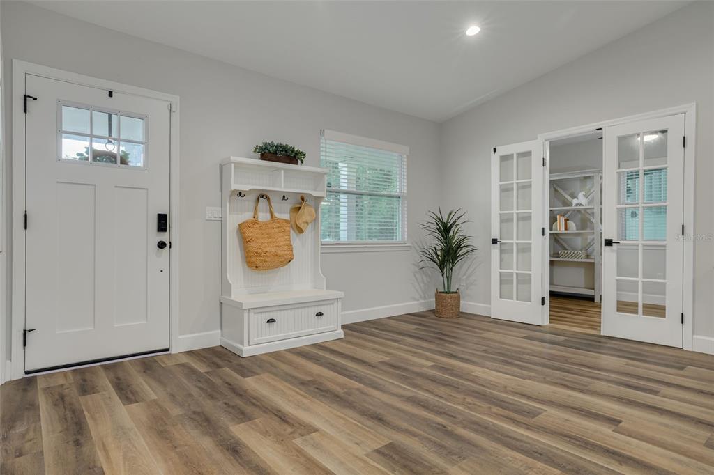 A bright entryway features a white hall tree, wood-look flooring, and French doors — 511 25TH AVENUE N, ST PETERSBURG, FL