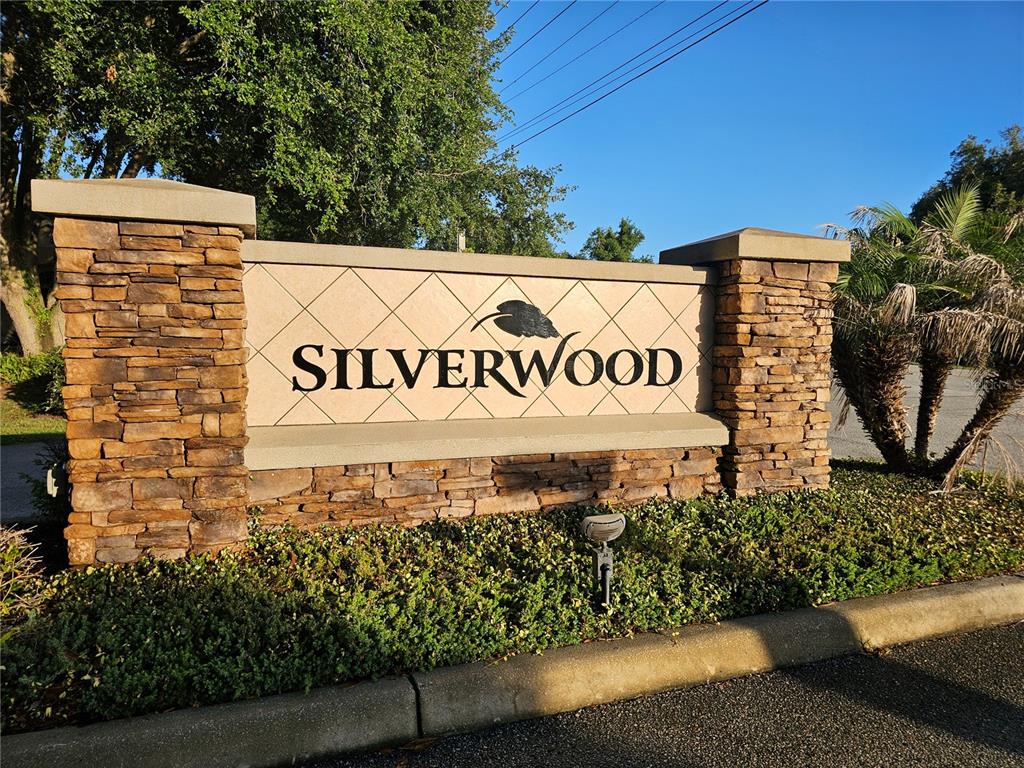 A bright yellow double front door with glass inserts sits between two white columns — 34224 SHADEWOOD CIRCLE, LEESBURG, FL