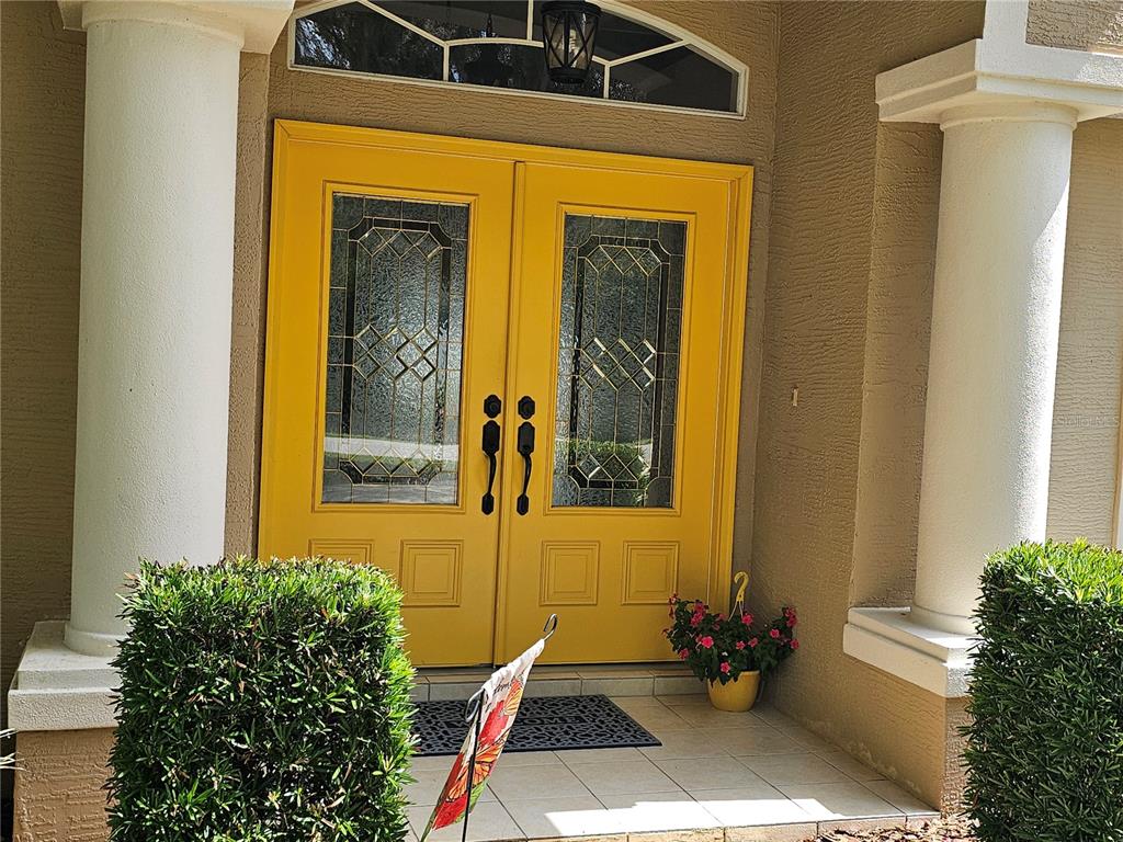 A single-story house with a tan exterior, a two-car garage, and a large oak tree — 34224 SHADEWOOD CIRCLE, LEESBURG, FL