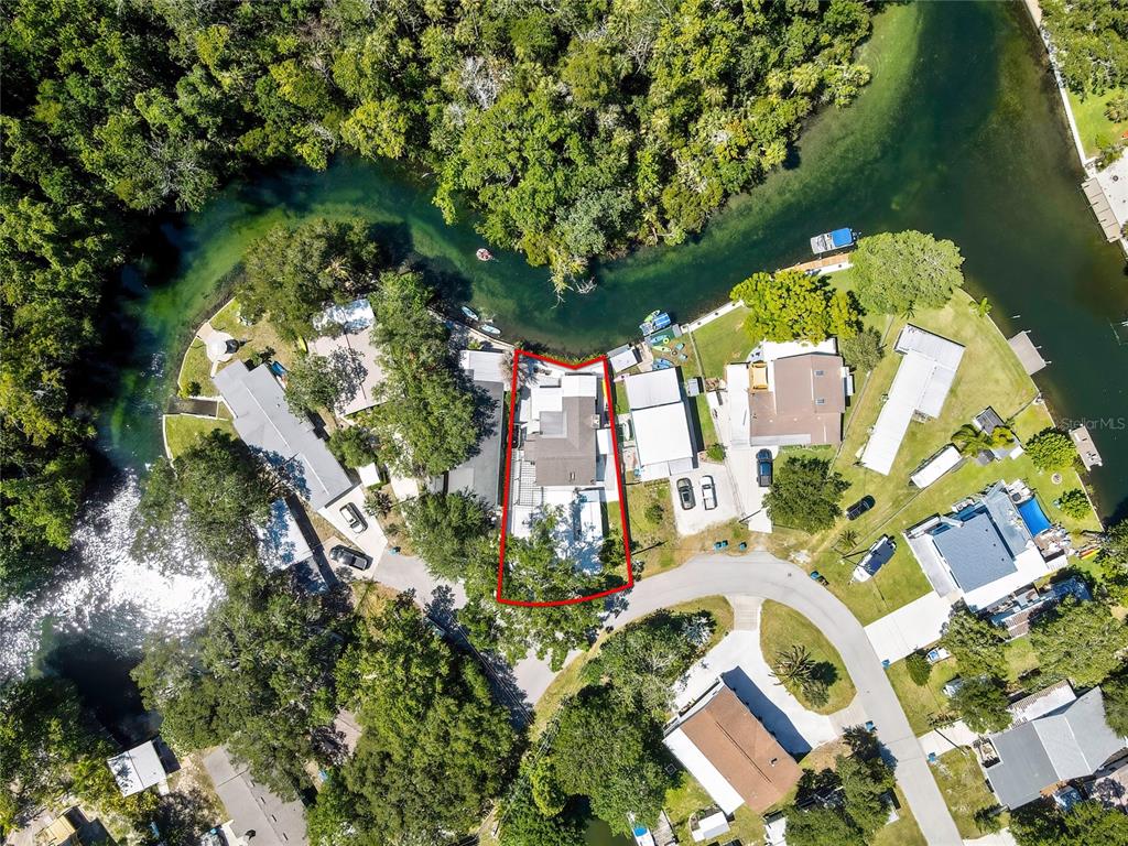 An aerial view shows a house with a red outline situated along a riverbank — 6080 WAVERLY ROAD, WEEKI WACHEE, FL