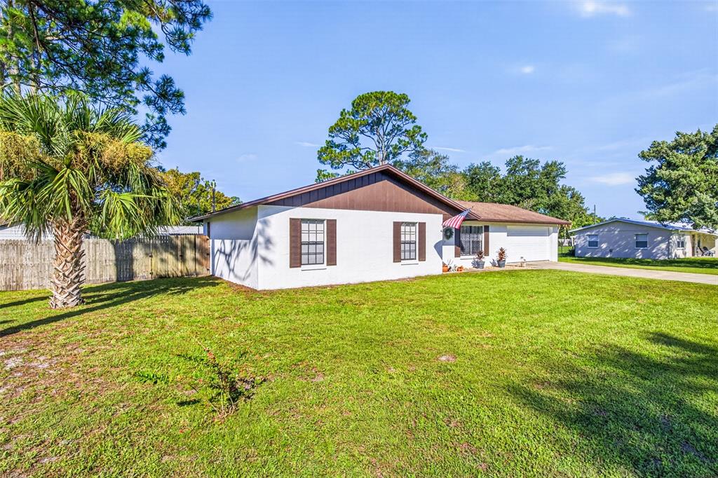 A white single-story house with brown trim and shutters sits on a grassy lawn — 2530 NORDMAN AVENUE, NEW SMYRNA BEACH, FL