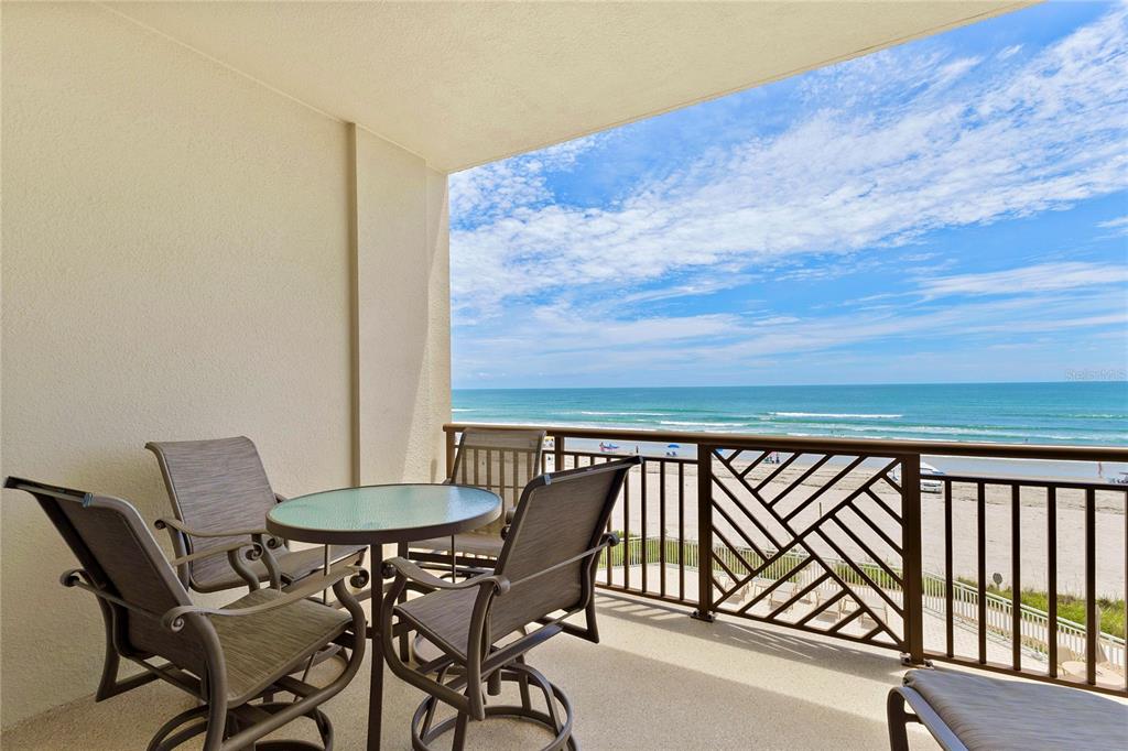 A hallway with light wood-look tile flooring leads toward an open living area — 807 S ATLANTIC AVENUE UNIT 303, NEW SMYRNA BEACH, FL
