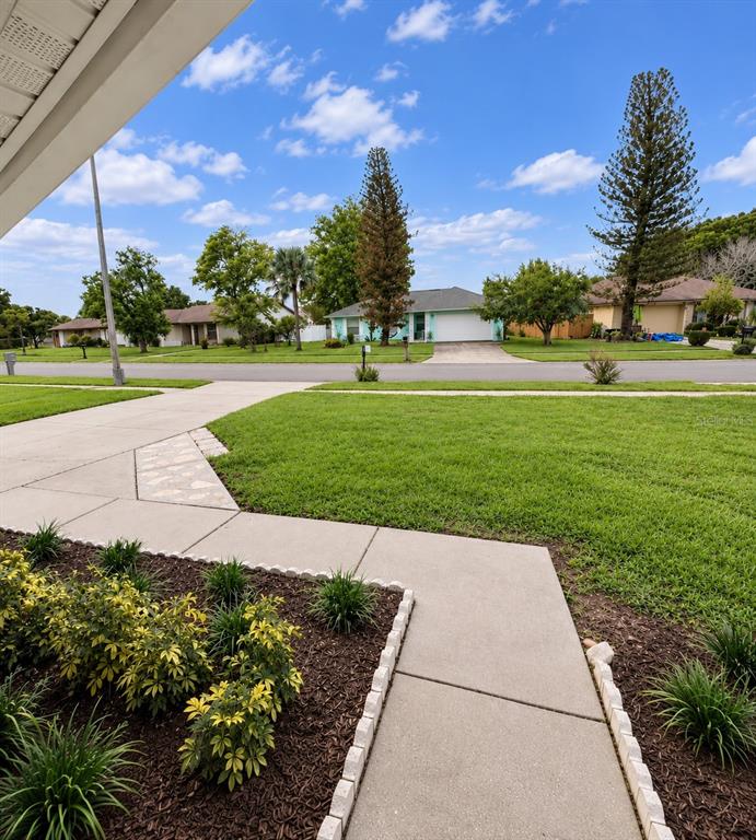 A large backyard features a house with a screened-in patio, two large trees, and a shed — 2658 CERAM AVENUE, ORLANDO, FL