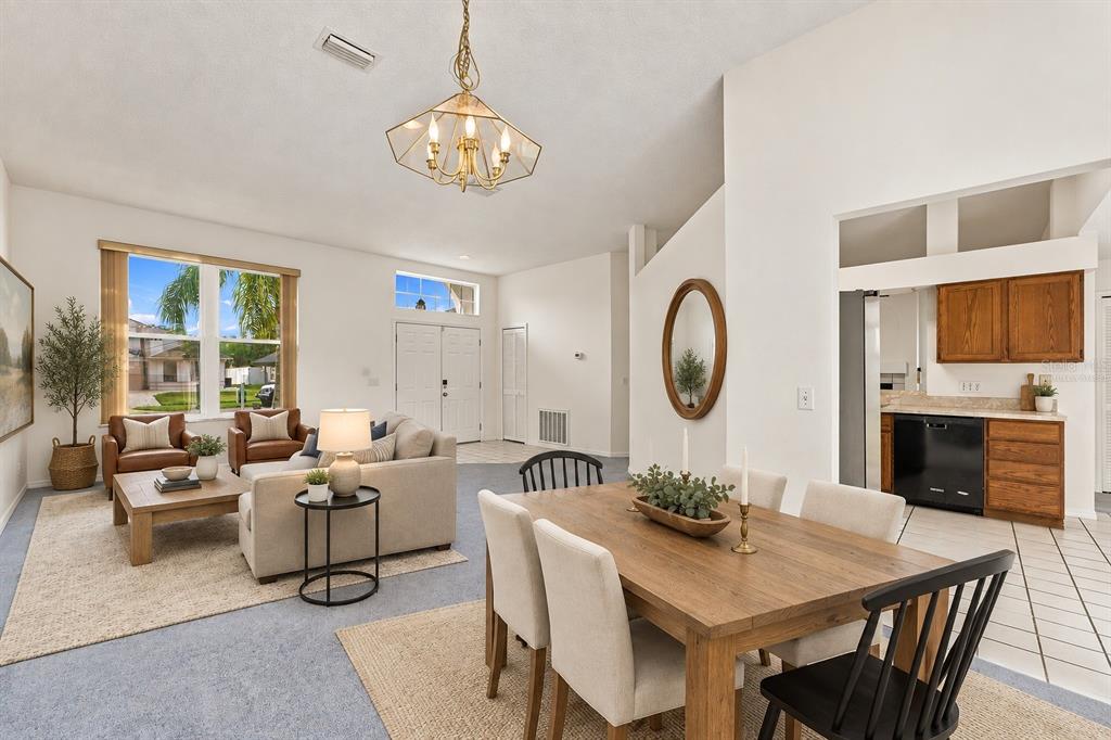 An open-concept living and dining area with light-colored walls, carpeted floors, and wood furniture — 5531 DELANO LANE, ORLANDO, FL