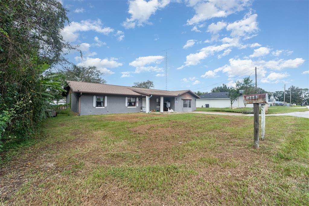 A single-story gray house with a brown roof sits on a grassy lot — 13678 SE 51ST AVENUE, SUMMERFIELD, FL