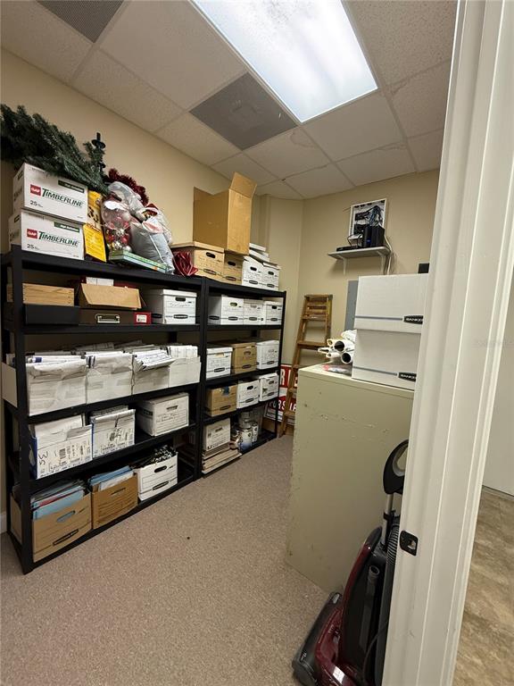 A storage room features black metal shelving units filled with boxes and a vacuum cleaner — 107 E 13TH STREET, ST CLOUD, FL