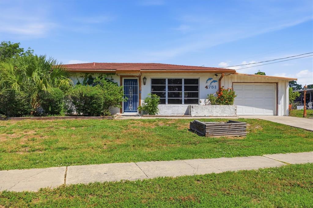 A single-story house with a white exterior, a red roof, and an attached garage — 4751 S BISCAYNE DRIVE, NORTH PORT, FL