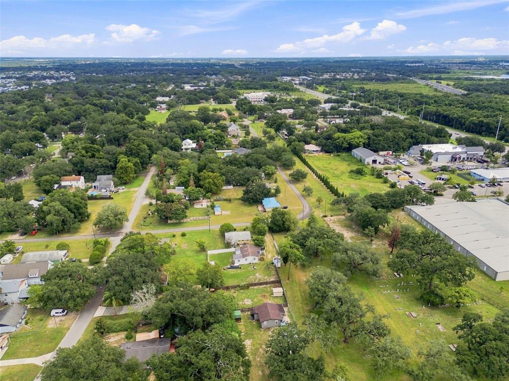 An aerial view shows a residential neighborhood with houses, trees, and a small cemetery — 320 W SADLER AVENUE, OAKLAND, FL