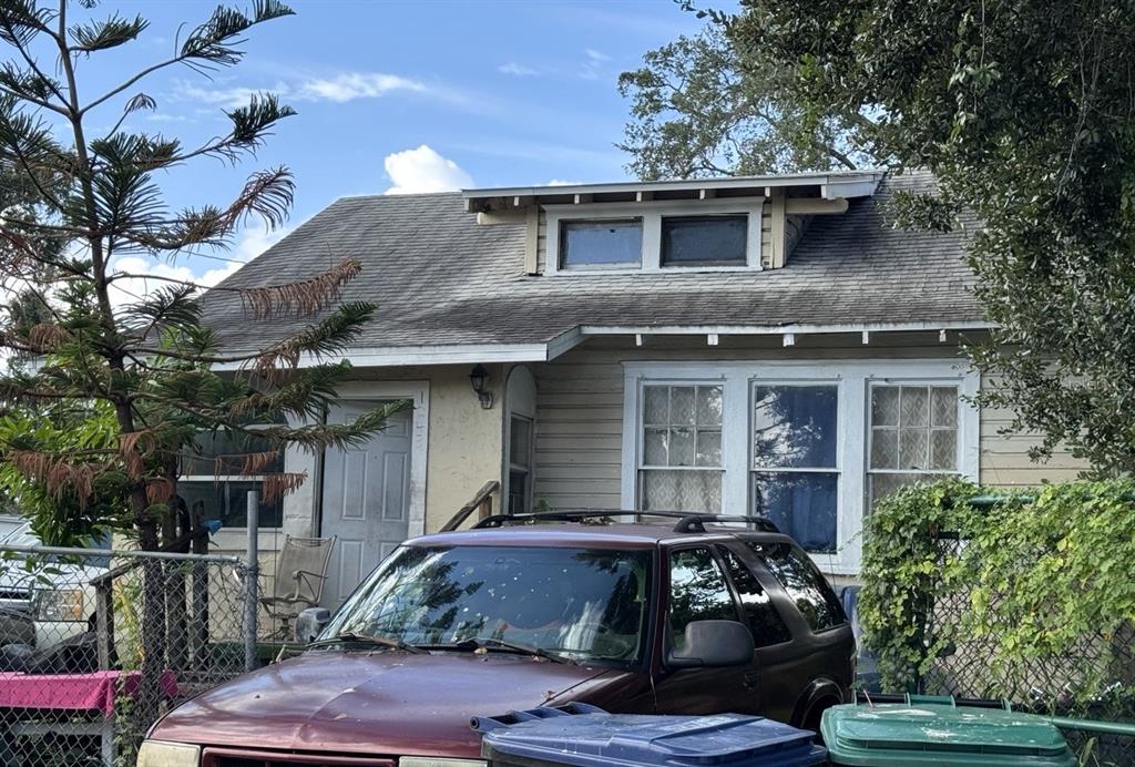 A one-story house with a dormer window, light-colored siding, and a maroon SUV parked outside — 1239 19TH STREET, ORLANDO, FL