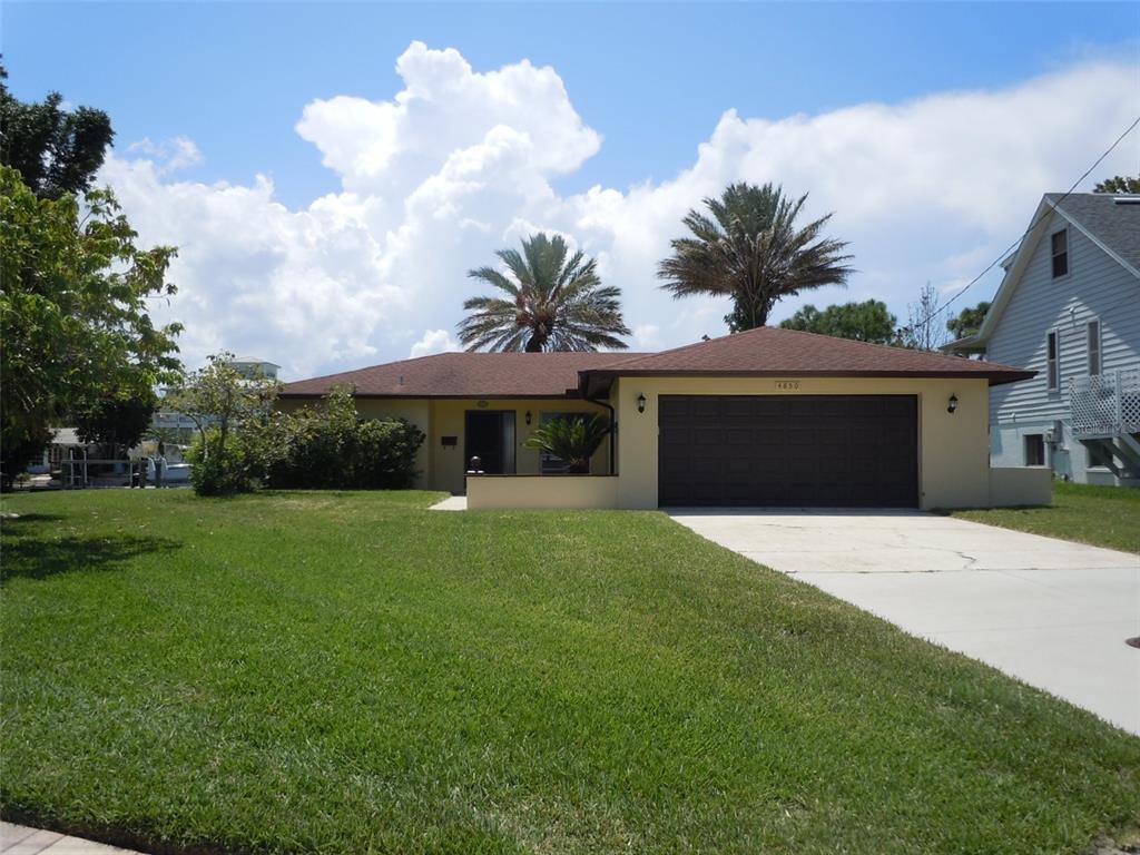 A single-story house with a brown roof, tan stucco exterior, and a two-car garage — 4850 BONITO DRIVE, NEW PORT RICHEY, FL
