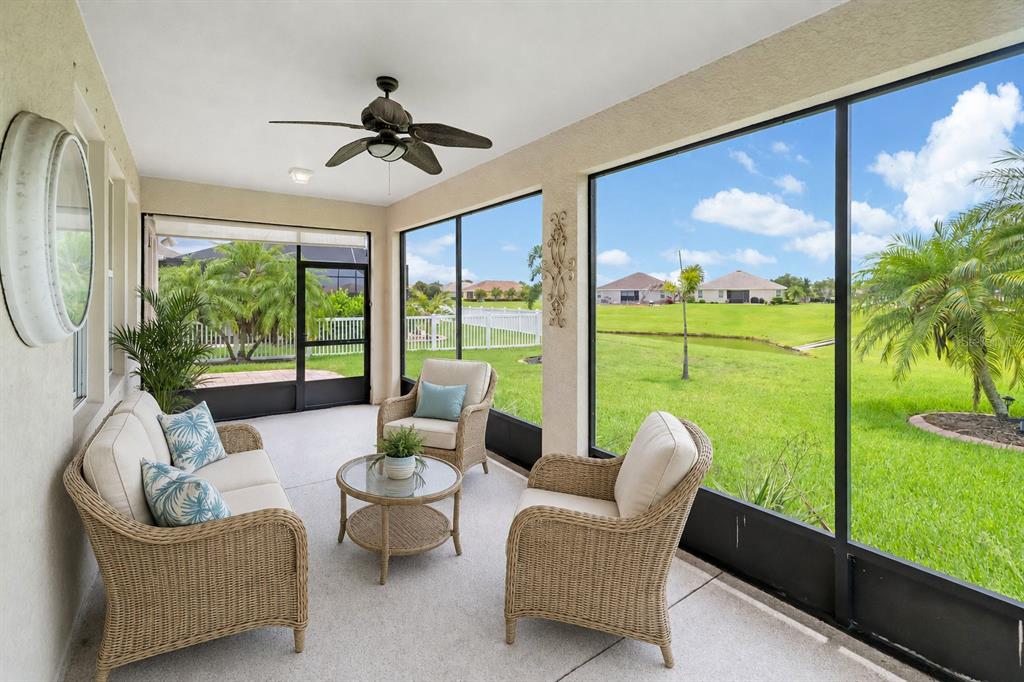 A screened-in patio features a ceiling fan, concrete flooring, and views of a grassy yard — 7726 111TH TERRACE E, PARRISH, FL