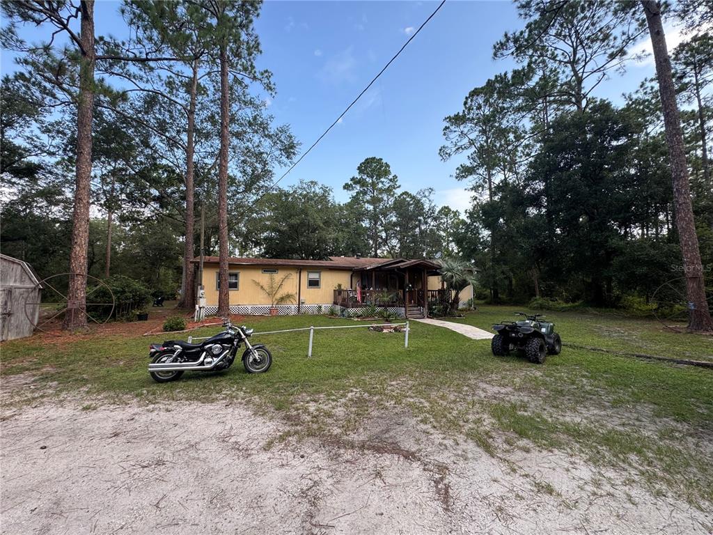 A yellow single-story house sits on a grassy lot with a motorcycle and an ATV — 2790 TOLER AVENUE, DELAND, FL